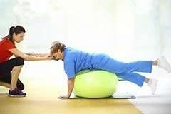 woman helping patient with physical therapy